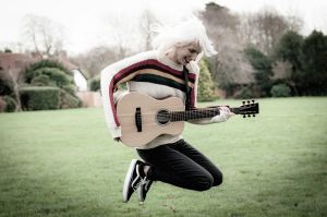 girl jump with guitar